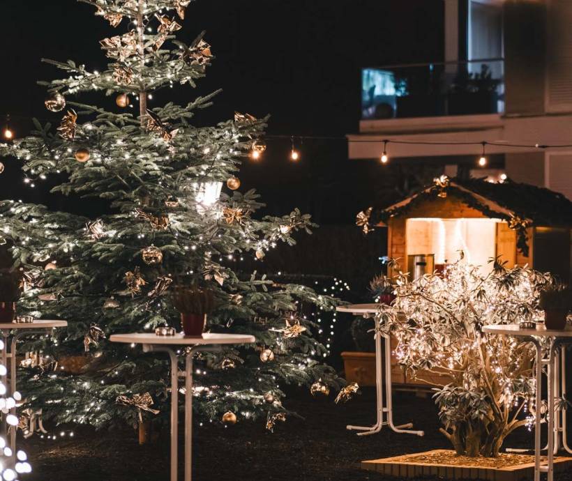 Large decorated Christmas tree with fairy lights in the warmly illuminated outdoor area of a hotel during the Christmas season on Rügen.