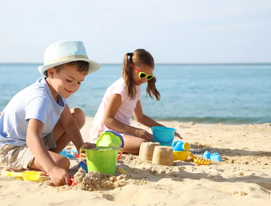 Kinder bauen Sandburgen am Strand der Ostsee während des Sommerurlaubs