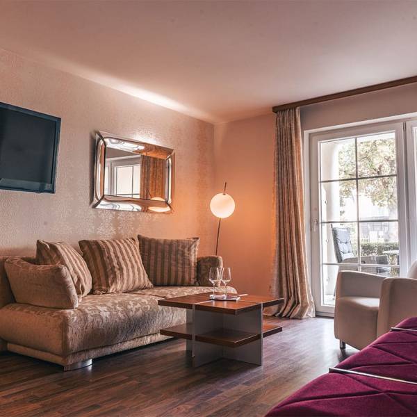 Sofa mit Beistelltisch und bodentiefem Fenster im Superior Studio der Arkona Strandresidenzen Binz