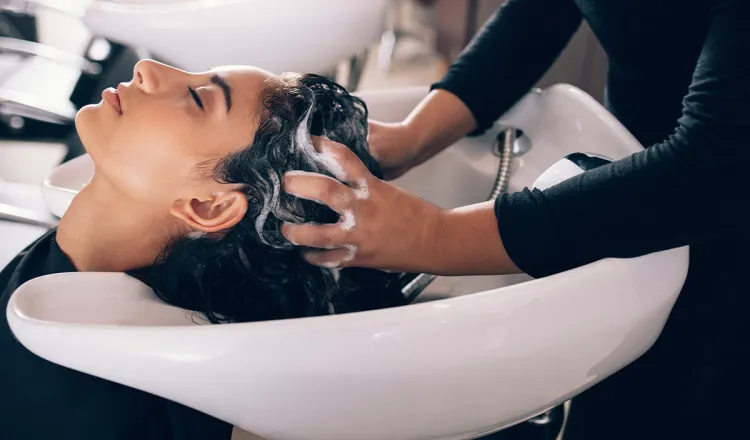 A woman enjoys a relaxing head massage while washing her hair at the Figaro hairdresser on the island of Rügen.