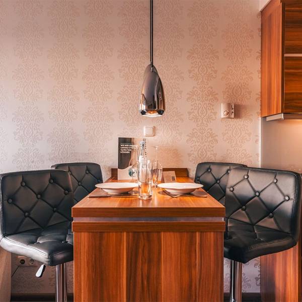 Esstisch im Deluxe Apartment der Arkona Strandresidenzen Binz mit Gedeck für zwei und moderner Wanddekoration